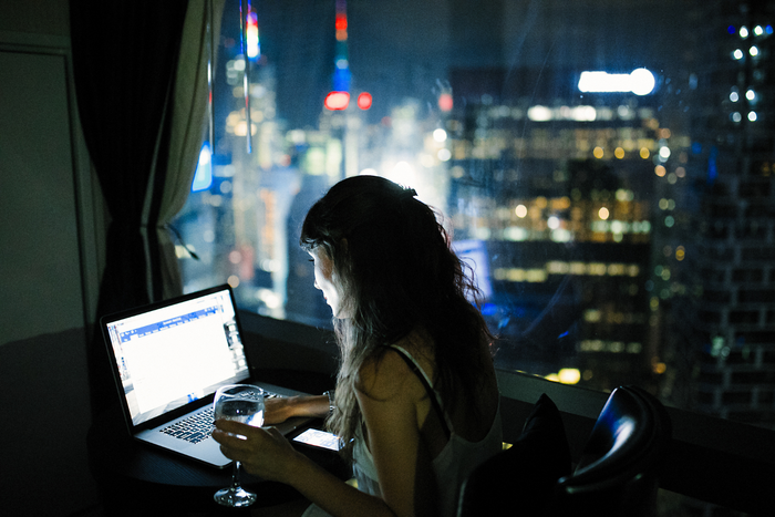Woman working in her laptop at night.