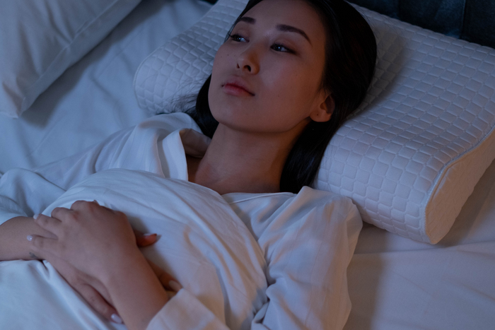 Woman lying in bed awake at night.