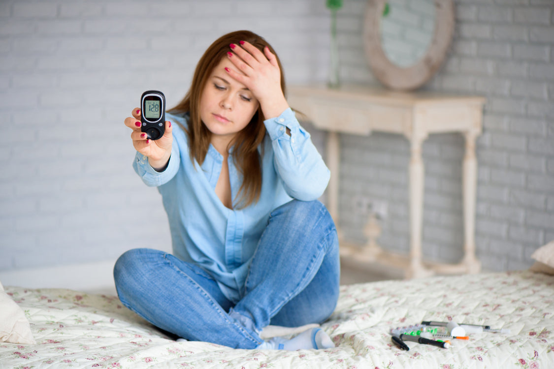 Woman checking blood sugar before sleep while feeling tired, showing link between blood sugar and sleep.