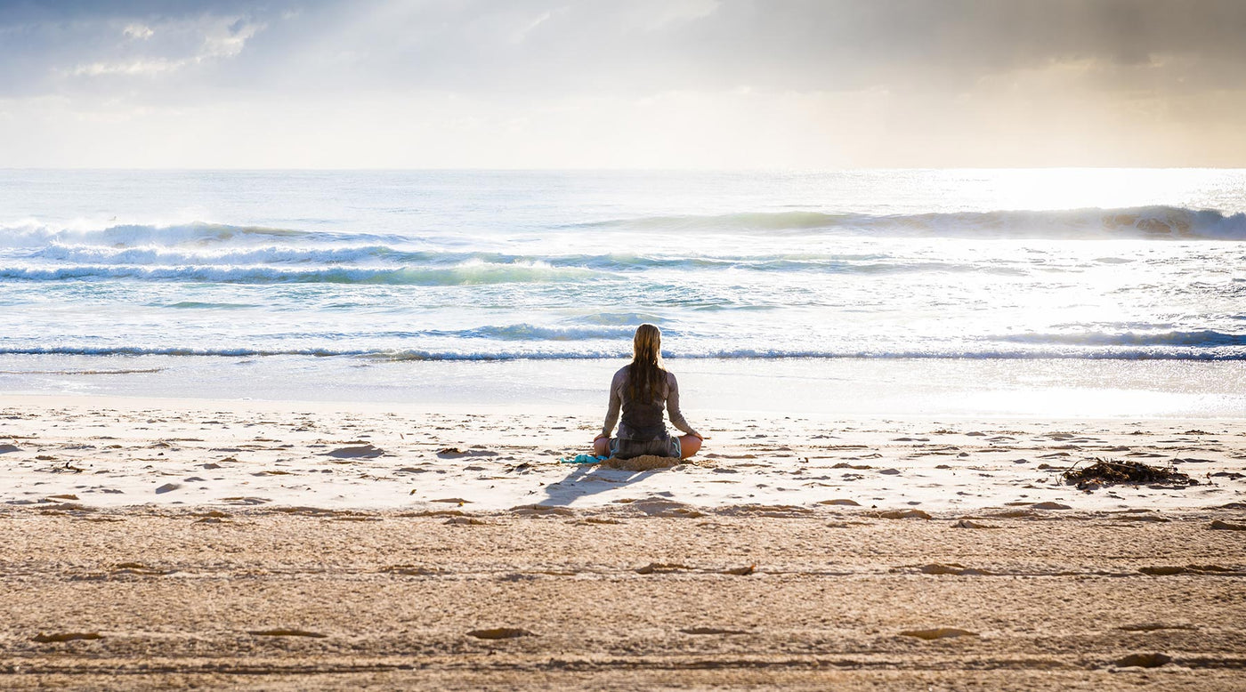 woman on beach reflecting life, relationships, and emotions