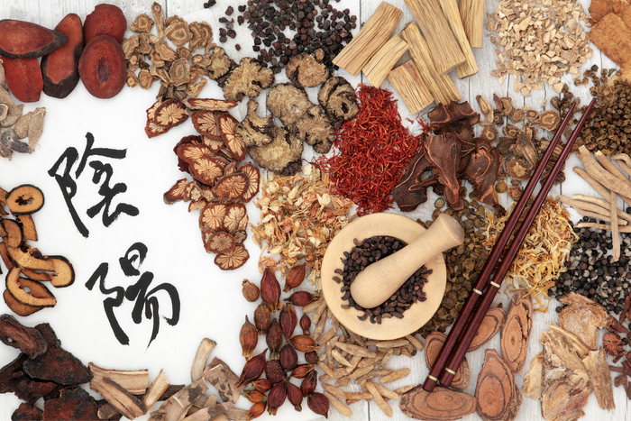 Selection of dried Chinese herbs for anxiety on a table with calligraphy