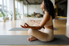 A woman practicing deep breathing in a seated yoga pose.