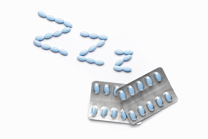 Blue oval pills are arranged in the shape of 