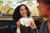 Two friends laughing while drinking coffee.