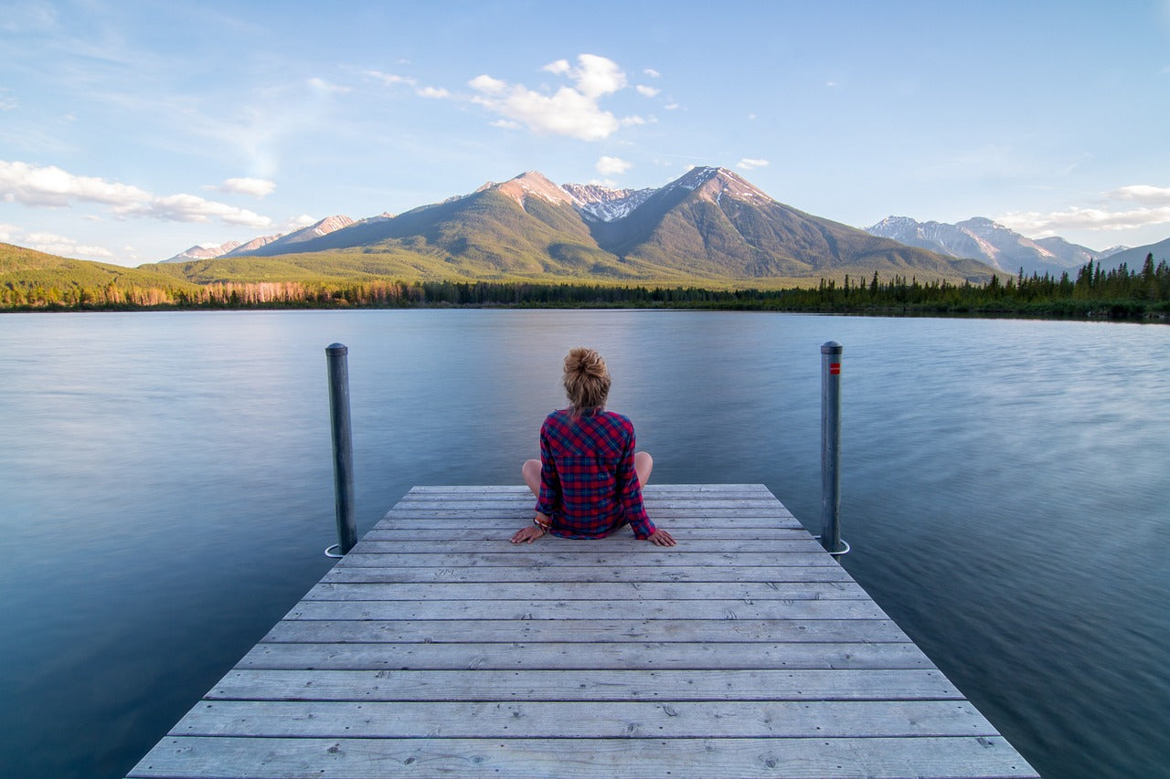 Person sitting on dock looking out at water