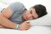 Man wearing a wristband sleep tracker while sleeping to record sleep stages