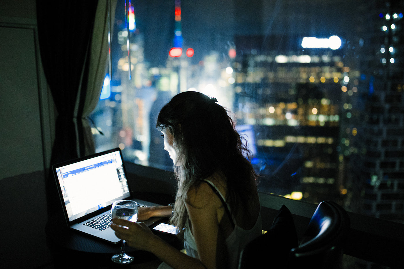 Woman working in her laptop at night.