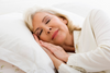 Older woman sleeping comfortably on white pillow