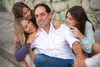 A family of four sitting together outdoors.