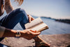 Person reading near ocean