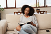 Woman writing in her journal while listening to music.