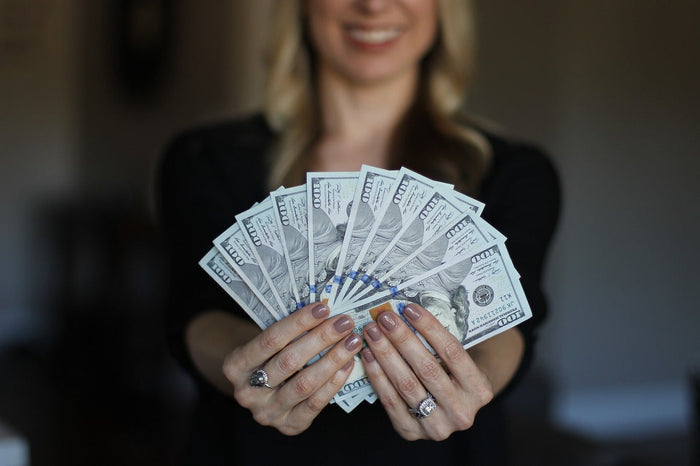 Smiling person holding up money